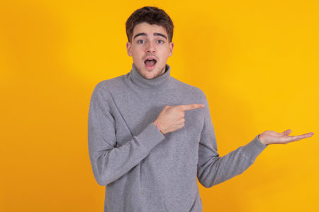 isolated young man pointing surprisedの写真素材