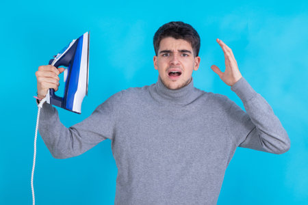 isolated man with clothes iron and stress expressionの写真素材