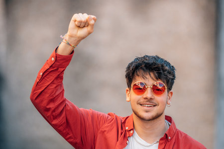 young man screaming excited with arms raised in successの写真素材