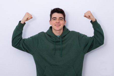 isolated teenager with arms raised in expression of successの写真素材