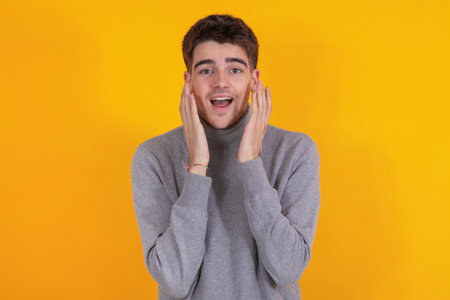 astonished or surprised young man isolated on backgroundの写真素材