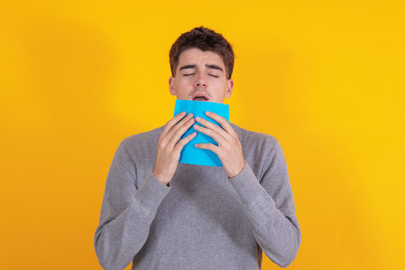 young man cold isolated on background sneezing or allergyの写真素材