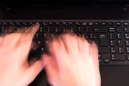 a person writes fast on the keyboard at the officeの写真素材