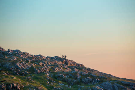 four friends on rocky hillside; Fogo Island, Newfoundlandの写真素材