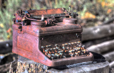 old rusty metal broken typewriter in bright sunlightの写真素材