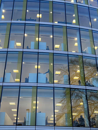 Close up of modern office building exterior with large regular oblong glass windows, the design...