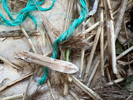 close up of Norfolk reed and drift wood branches with wound rope material for workshop to bind twine...