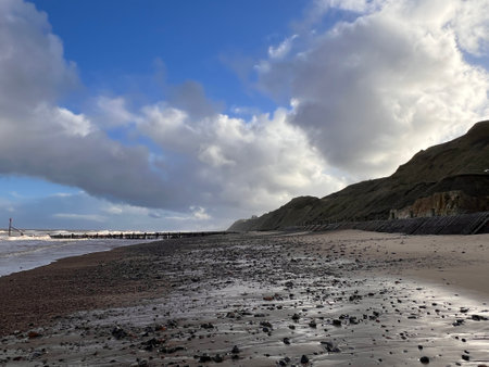 Landscape dramatic view sandy beach shore out with coastline stormy cloudy beautiful Winter day surf waves high wind and dramatic grey sky in Winter Norfolk  East Anglia ukの写真素材