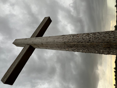 Landscape with large wooden cross at the ruin site of St Benet's Abbey on Norfolk Broads uk in stormy weather,looking upwards to cloudy sky a conceptual image of faith.の写真素材