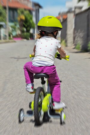 little kid bicycling on the streetの写真素材