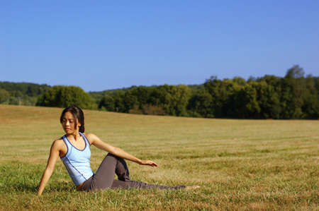 Girl practicing yoga in a summer meadow.