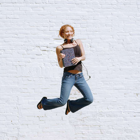 Attractive urban girl against white brick wall.