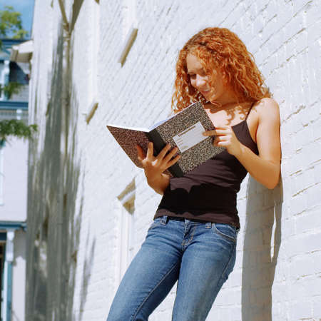 Attractive urban girl against white brick wall.