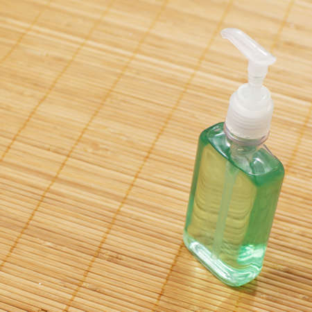 A soap bottle on display against a bamboo mat.の写真素材