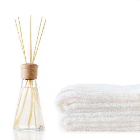 Diffuser and stack of towels against a white background.の写真素材