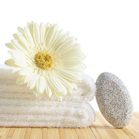 Towels, pumice stone, and flower against a white background.の写真素材