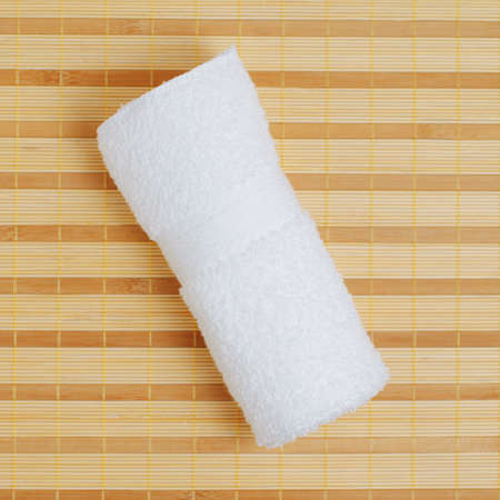 White towel against bamboo reed mat background.の写真素材
