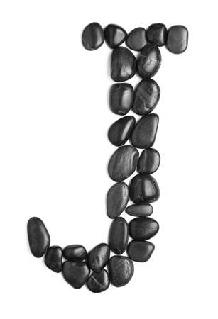 Black rock letter photographed against a white background.の写真素材