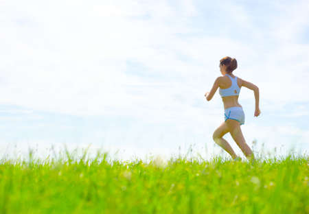 Mature woman athlete practicing in a spring meadow, from a complete series.の写真素材