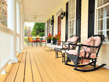 Low angle view of a large front porch with furniture and potted plants. Vertical format.の写真素材