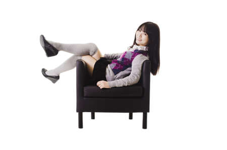 Chinese student in a school uniform sitting in a leather chair.の写真素材