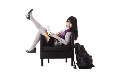 Chinese student in a school uniform sitting in a leather chair.の写真素材