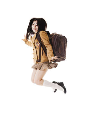 Female Chinese student wearing a backpack on a white background jumping into the air.の写真素材
