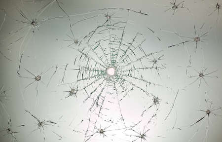 There is a broken car glass of windscreen with hole in picture centerの写真素材