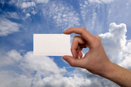 There is arm with white card on blue sky backgroundの写真素材
