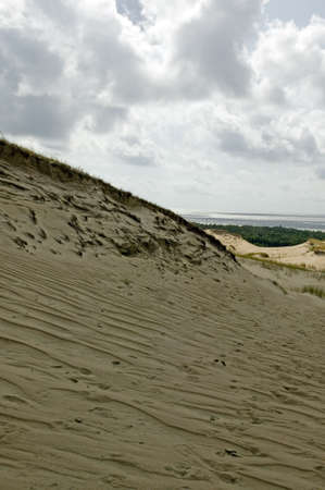 There is a dune with sky and cloudsの写真素材