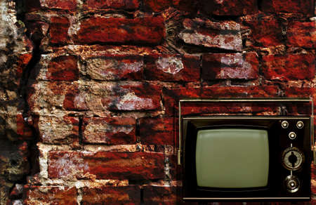 Old tv box with grunge antique wall backgroundの写真素材