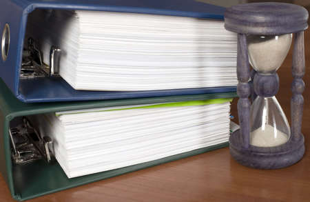 There is a block of documents and sand clockの写真素材