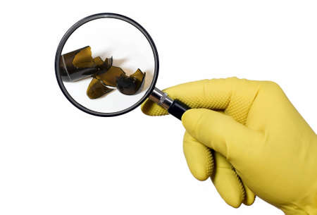 Yellow gloved cleaner is searching with magnifying glassの写真素材