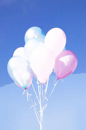 Colorful animated balloons with strings on blue backgroundの写真素材