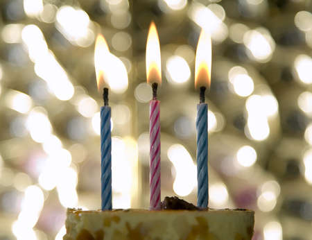 Cake with candle and flame on celebration theme backgroundの写真素材