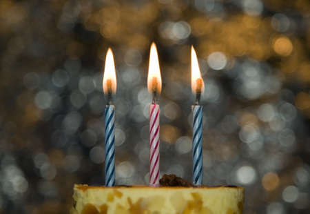 Cake with candle and flame on celebration theme backgroundの写真素材