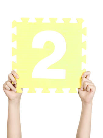 Child is holding number two in his handの写真素材