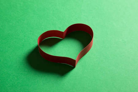 Heart frame made from paper on green background, valentine conceptの写真素材