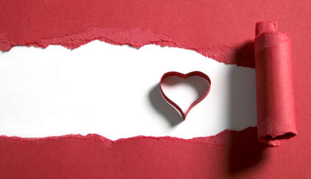 Ripped red paper with white space and heart shapeの写真素材