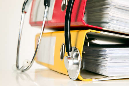 A medicine stethoscope is lying on bunch of paperの写真素材