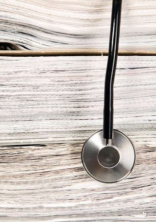 A medicine stethoscope is lying on bunch of paper