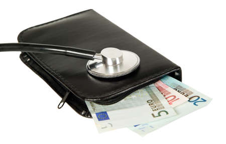 A medicine stethoscope is lying on black purse with moneyの写真素材
