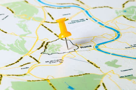 Thumbtack in the world map, close up, paper background