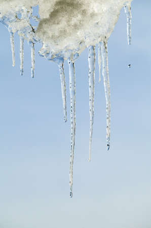There are icicles frame on cloudy sky background