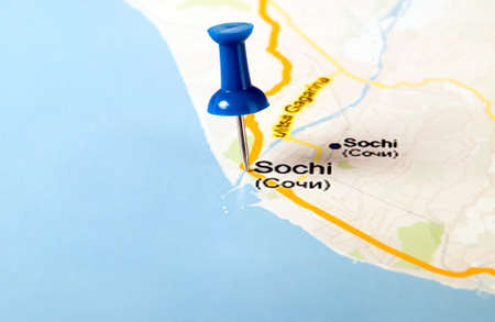 Thumbtack in the world map, close up, paper background