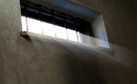Light is coming through the barred window, hope concept