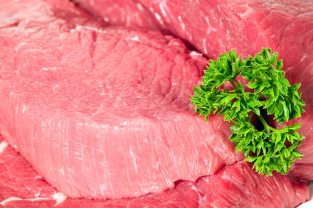 Raw sliced meat with green parsley, backgroundの写真素材