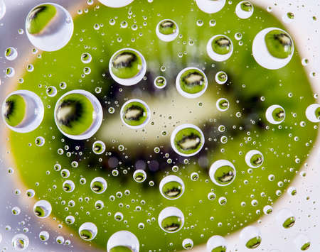 Background from green fruit kiwi with water drops, food conceptの写真素材