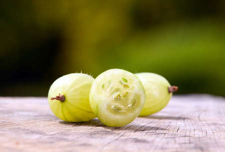 Some gooseberries placed on table with green nature background behindの写真素材