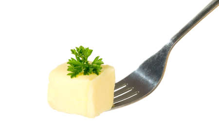 Yellow butter with parsley is being hold with fork, food conceptの写真素材